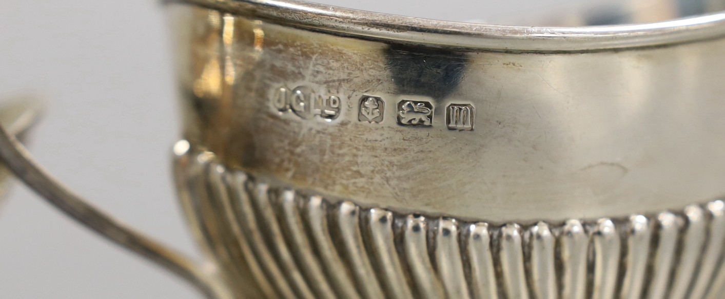 A George V demi fluted silver cream jug and sugar bowl, Birmingham, 1911 and a pair of pierced silver bonbon dishes, Birmingham, 1928, 8oz.